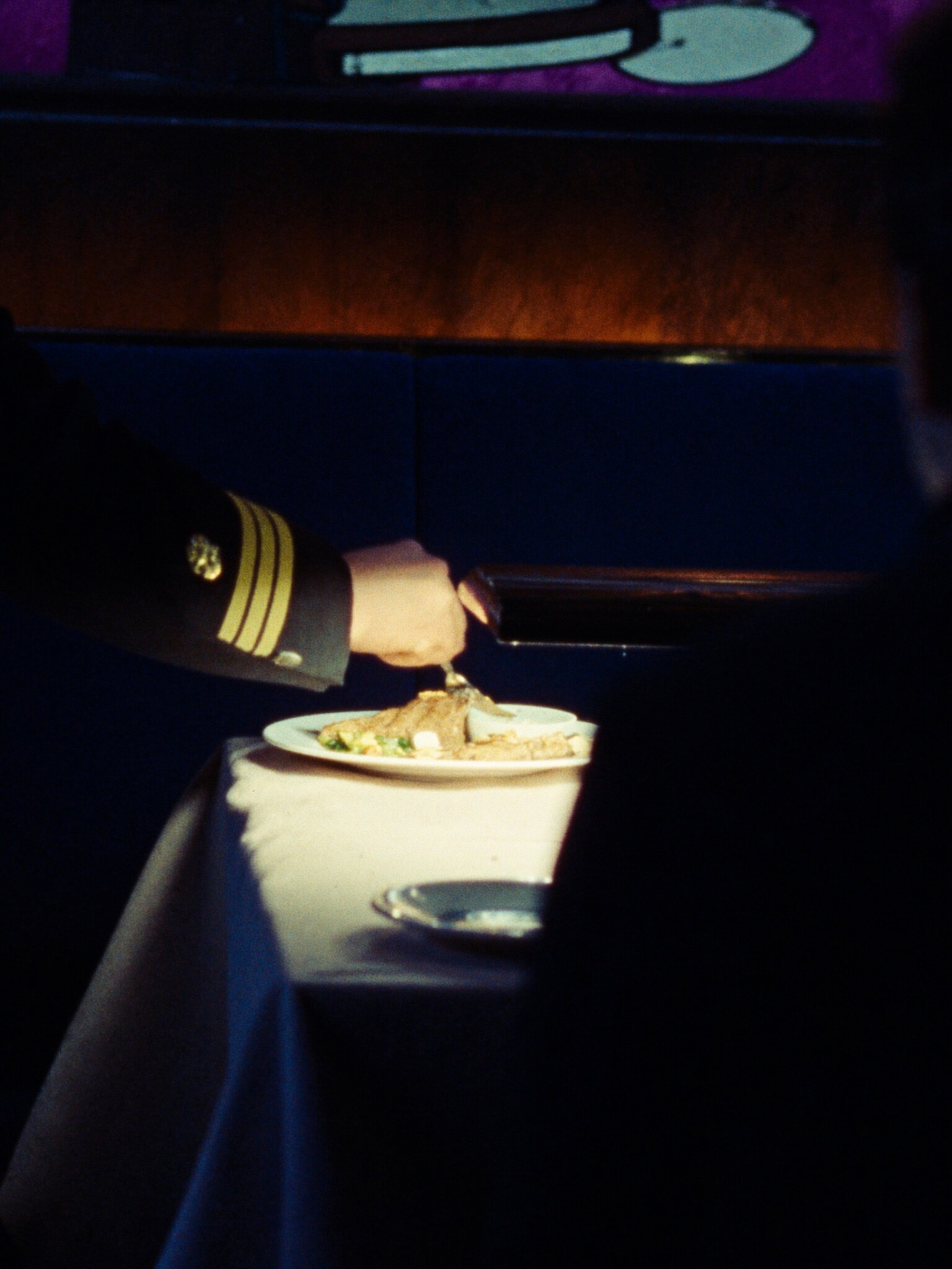 Service at the banquette. Plates finished in front of you, in the light.